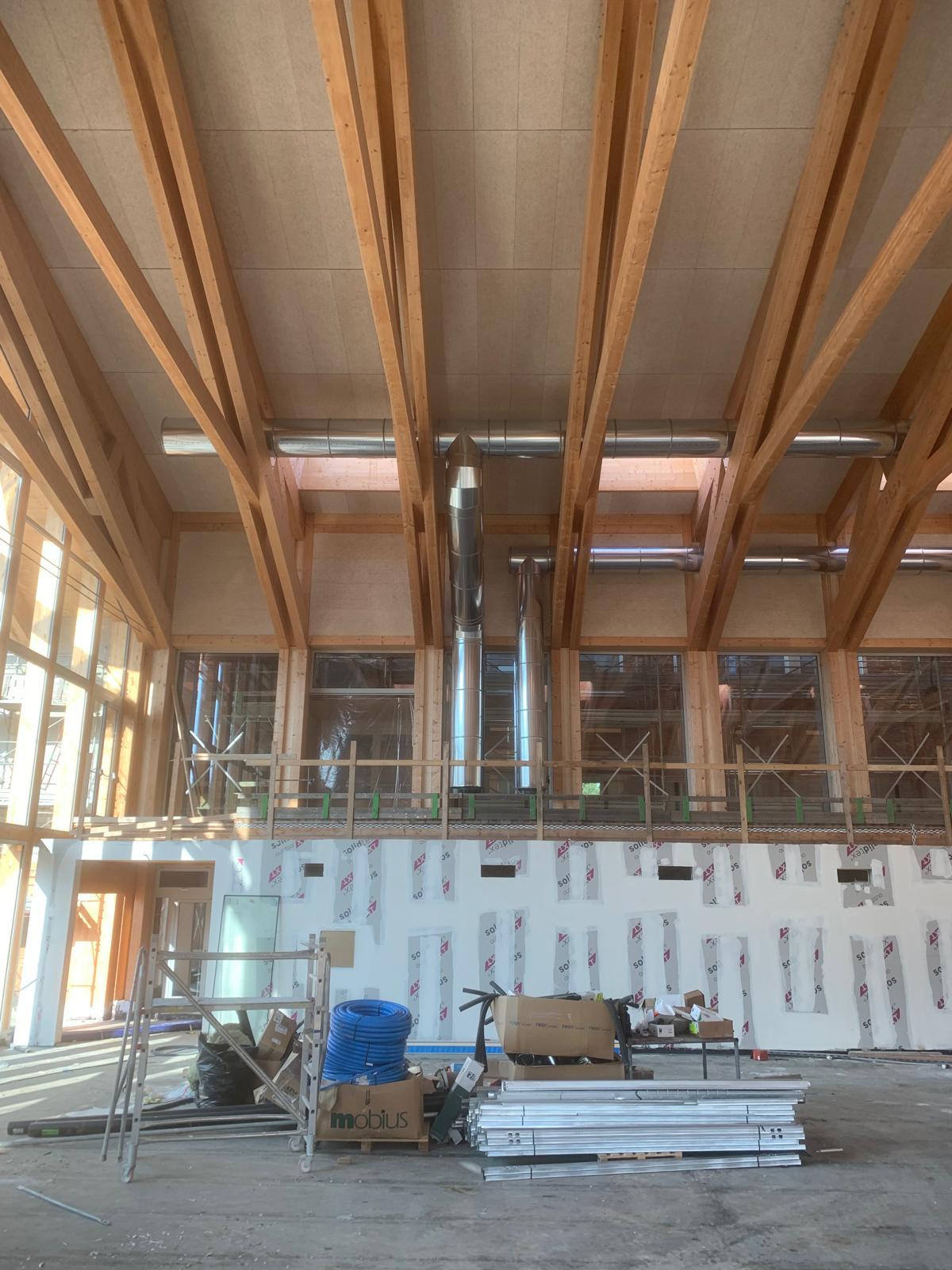 Canali sospesi in capannone con travi in legno